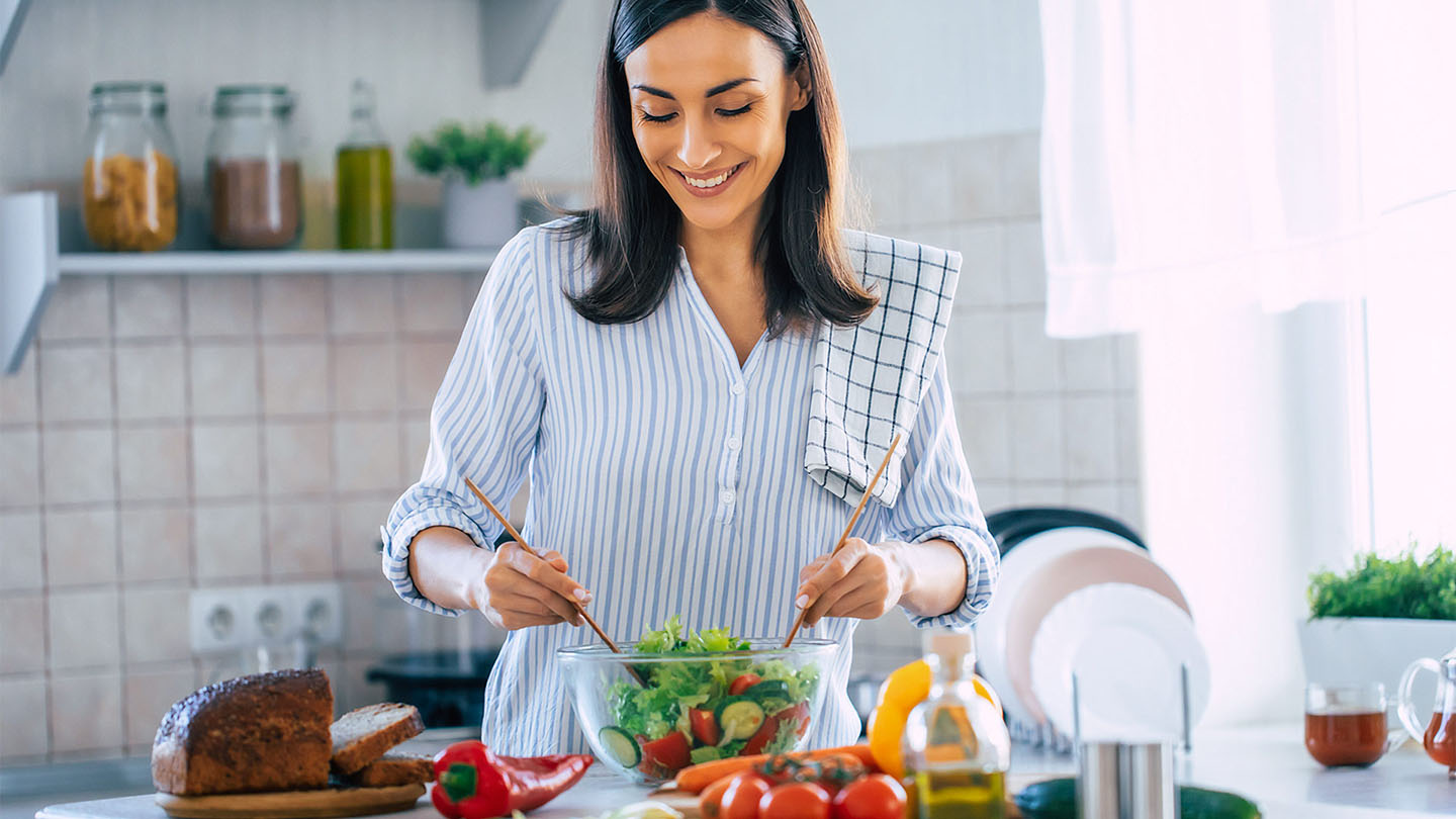 Mlada ženska pripravlja zdrav obrok.