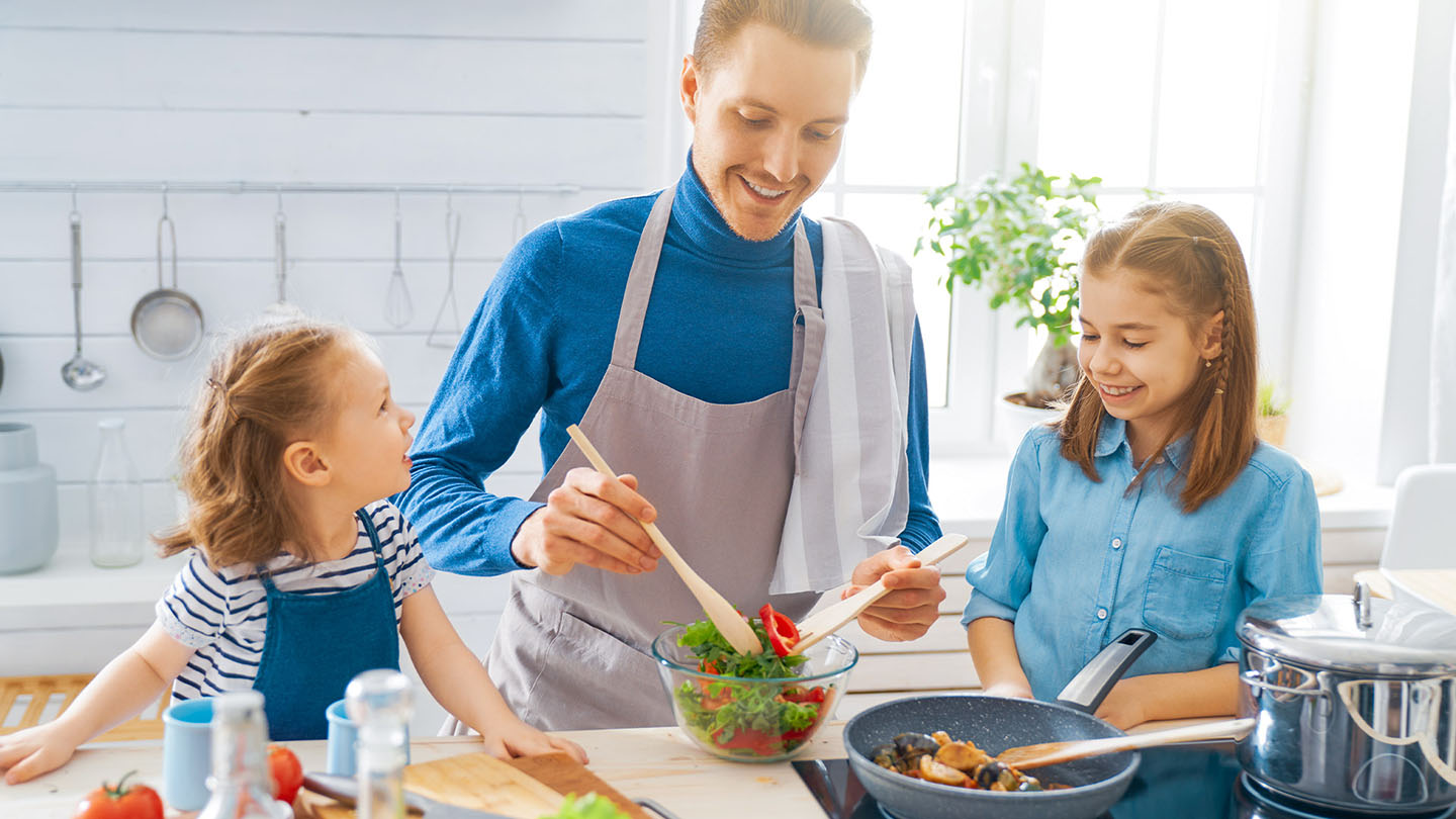Družinica pripravlja zdrav obrok v kuhinji.