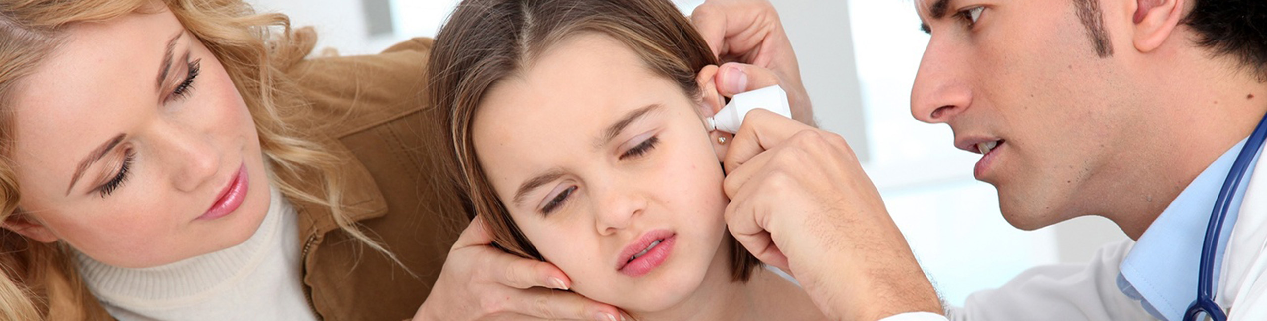 Deklica na pregledu pri zdravniku zaradi vnetja ušesa.