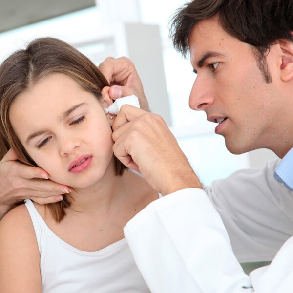 Deklica na pregledu pri zdravniku zaradi vnetja ušesa.