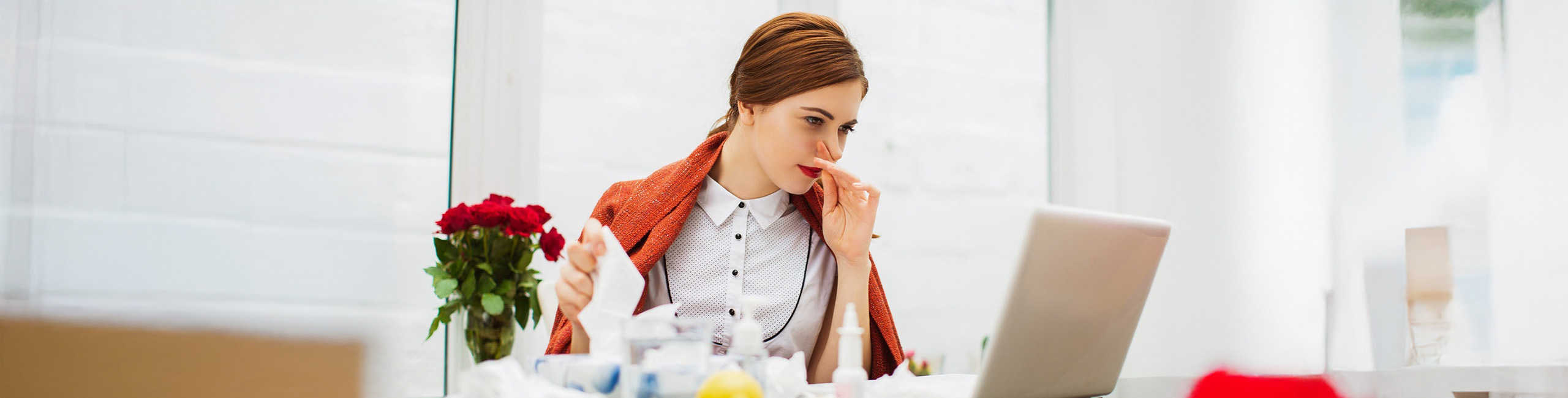 Prehlajena bolna ženska v pisarni.