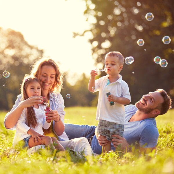 Brezskrbna, zdrava družina se igra na prostem.