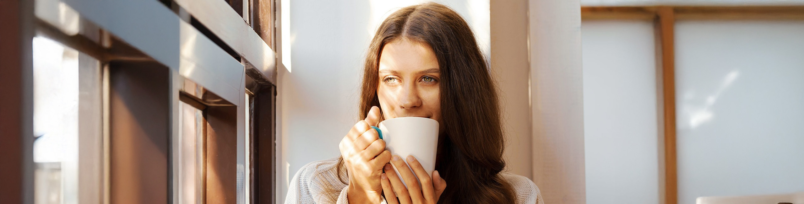 Prehlajena ženska pije čaj.