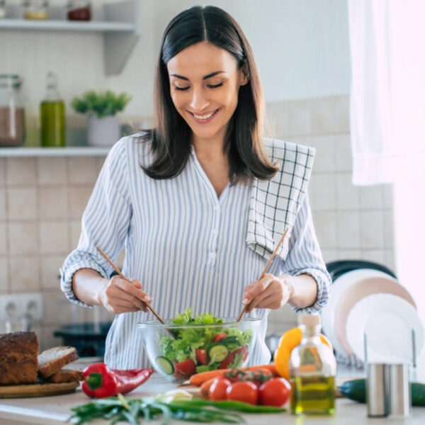 Ženska pripravlja zdravo solato, polno vitamina C in cinka.