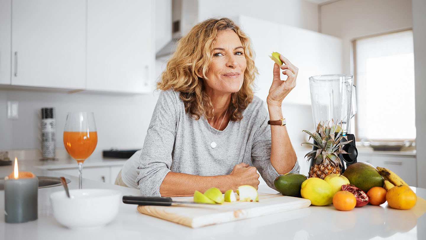 Zdrava ženska je sadje v kuhijni.